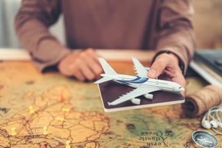 Hands Showing Model Airplane And Passport Above World Map And Book Magnifying Glass Compass Hands Showing Model Airplane And Passport Above World Map And Book Magnifying Glass Compass