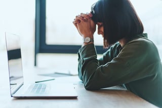 Side View of Exhausted Business Woman Searching for Solution Using Laptop Side View of Exhausted Business Woman Searching for Solution Using Laptop
