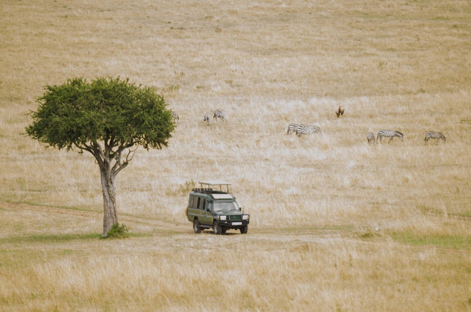 Safari Car Travelling Through The Kenyan Savannah