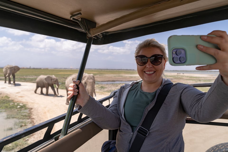 Tourist taking a safari selfie with elephants